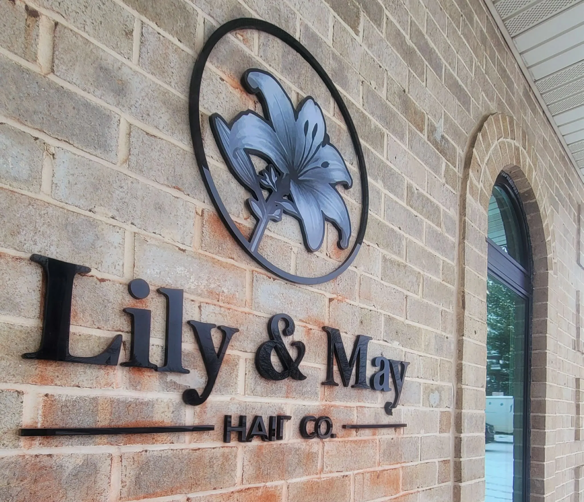 The signature lily on the brick wall at Lily & May Hair Co. in Lancaster, PA.